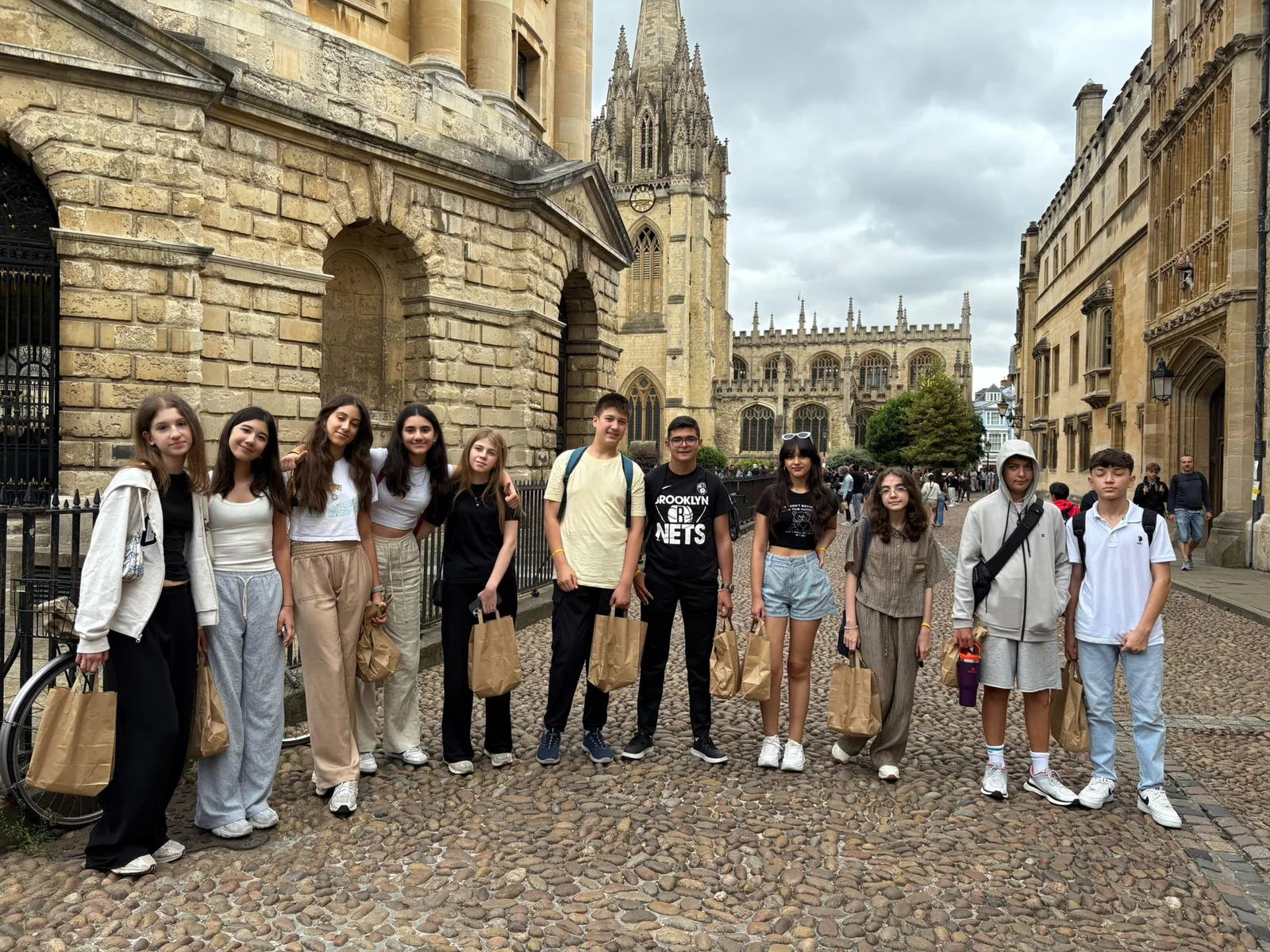 Oxford’da tarihi bir üniversite binasının önünde duran öğrenci grubu